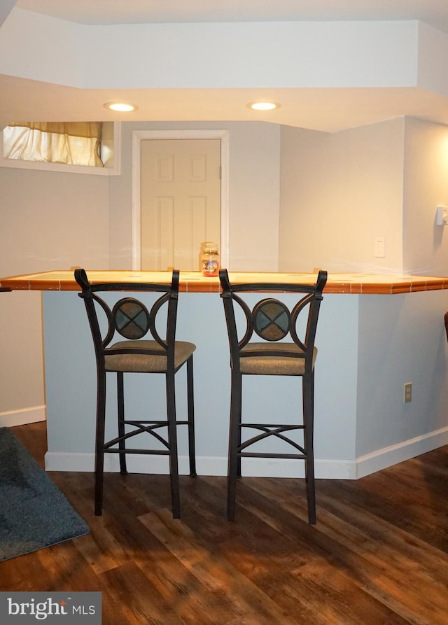 dining space featuring dark wood-style flooring, baseboards, and recessed lighting