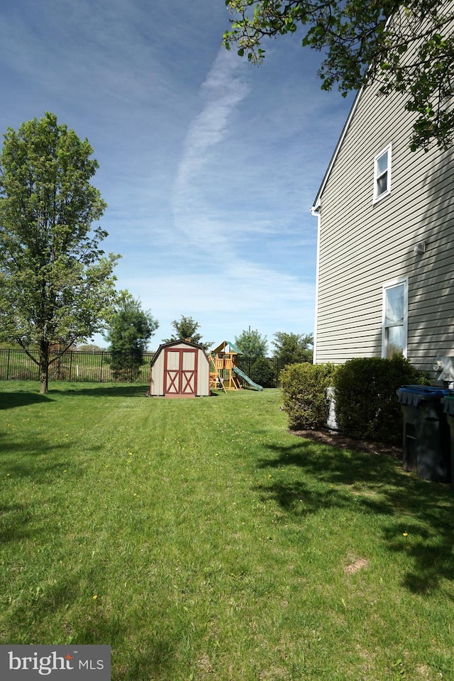view of yard featuring a shed, an outbuilding, and a playground