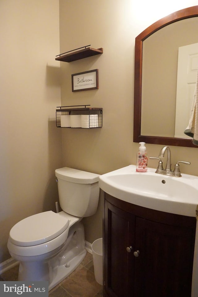 bathroom featuring vanity, toilet, baseboards, and tile patterned floors