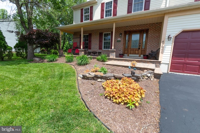 4361 Sutton Cir, Reading, PA 19606 - view of front of home with a porch, brick siding, a front lawn, and a garage