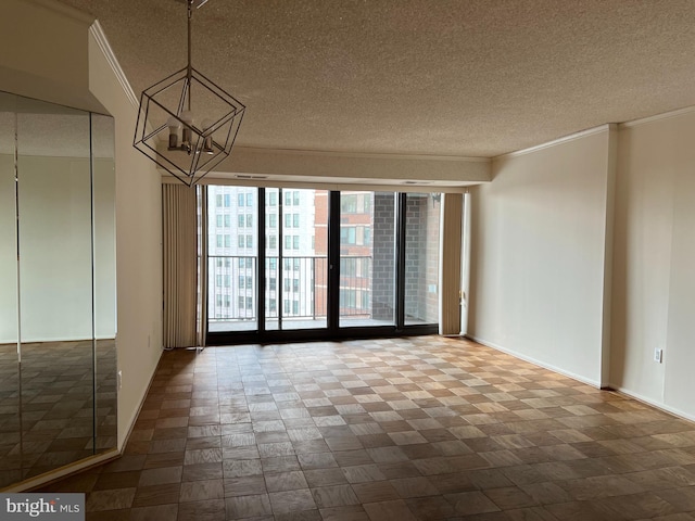 unfurnished room with a textured ceiling, a chandelier, crown molding, expansive windows, and baseboards