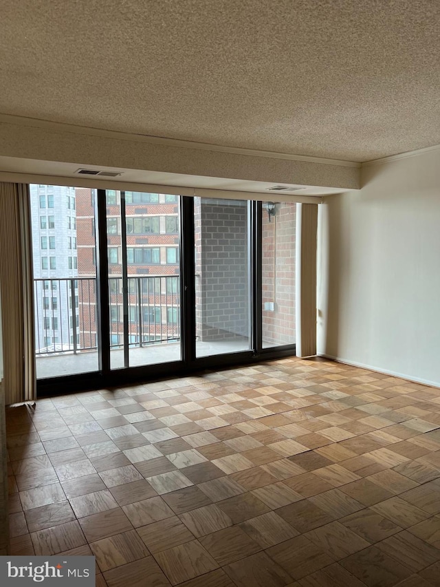 spare room with a textured ceiling and baseboards