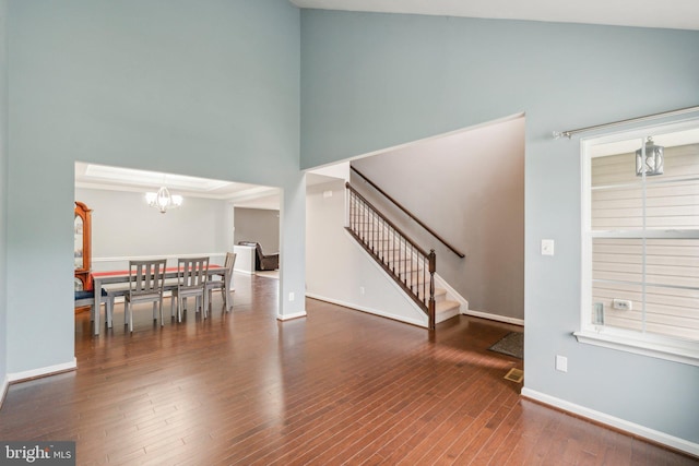 199 Colbert St, Taneytown, MD 21787 - unfurnished living room featuring stairway, a chandelier, wood finished floors, baseboards, and a towering ceiling