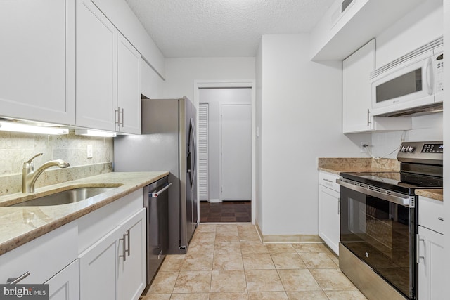 3800 Fairfax Dr Unit 1011, Arlington, VA 22203 - kitchen with stainless steel appliances, a sink, light stone countertops, white cabinetry, and a textured ceiling