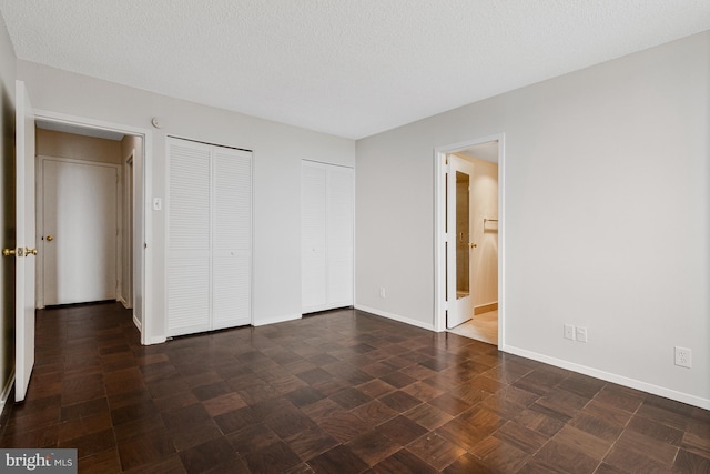 3800 Fairfax Dr Unit 1011, Arlington, VA 22203 - unfurnished bedroom featuring two closets, baseboards, connected bathroom, and a textured ceiling