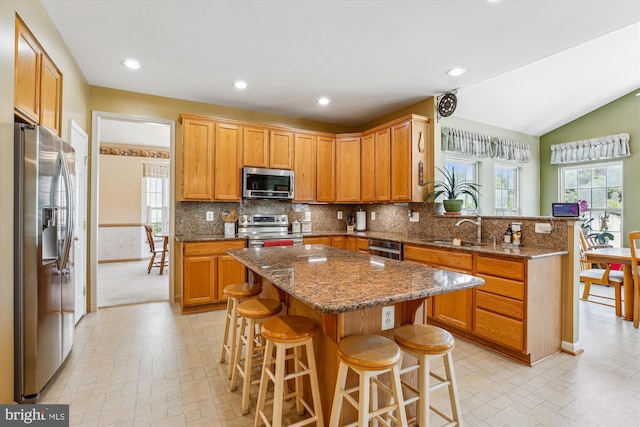 7229 Antares Dr, Gaithersburg, MD 20879 - kitchen with appliances with stainless steel finishes, a sink, a kitchen bar, decorative backsplash, and a peninsula
