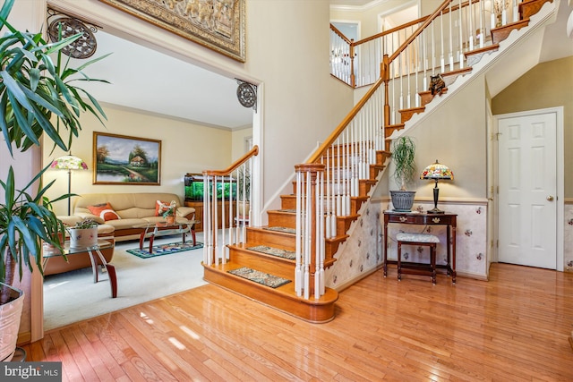 7229 Antares Dr, Gaithersburg, MD 20879 - staircase with wood-type flooring, a high ceiling, wainscoting, and ornamental molding