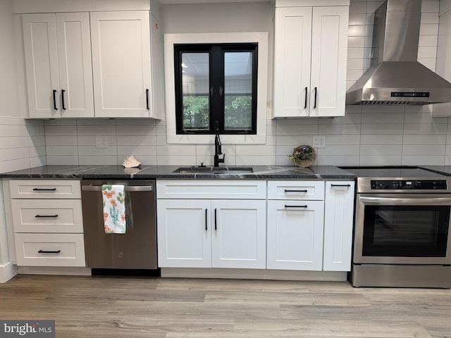 5 Kent Ave, Ocean View, DE 19970 - kitchen featuring stainless steel appliances, wall chimney exhaust hood, a sink, decorative backsplash, and dark stone countertops