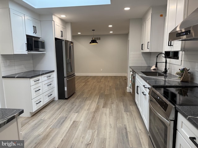 5 Kent Ave, Ocean View, DE 19970 - kitchen featuring stainless steel appliances, ventilation hood, a sink, light wood-style floors, and white cabinetry