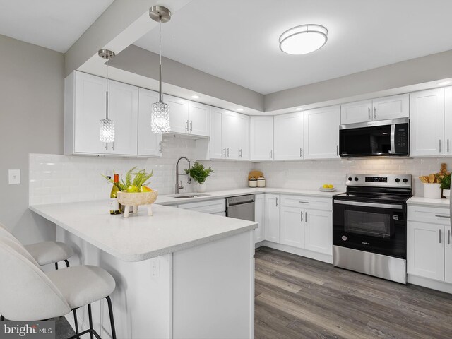 108 Kingsway Dr, Riviera Beach, MD 21122 - kitchen featuring appliances with stainless steel finishes, a sink, a peninsula, and white cabinetry