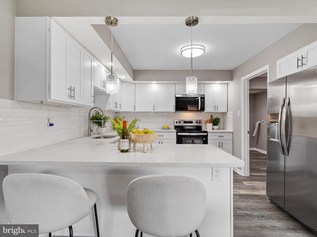108 Kingsway Dr, Riviera Beach, MD 21122 - kitchen featuring stainless steel appliances, a sink, a peninsula, dark wood-type flooring, and tasteful backsplash
