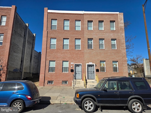 view of property with entry steps and uncovered parking