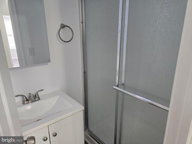 bathroom featuring vanity and a shower with door