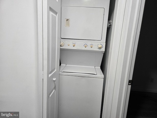 clothes washing area with stacked washer / dryer