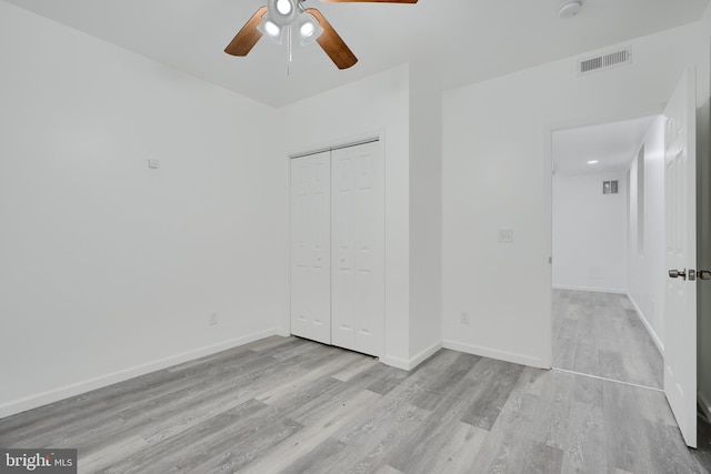 unfurnished bedroom featuring light wood finished floors, a closet, and baseboards