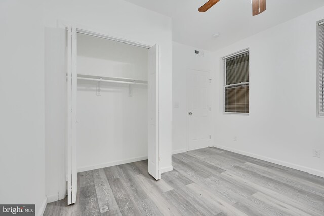 unfurnished bedroom with wood finished floors, a closet, and baseboards