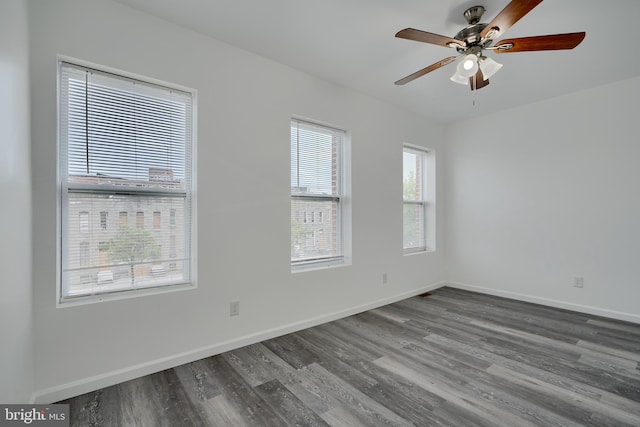 spare room featuring wood finished floors, ceiling fan, and baseboards