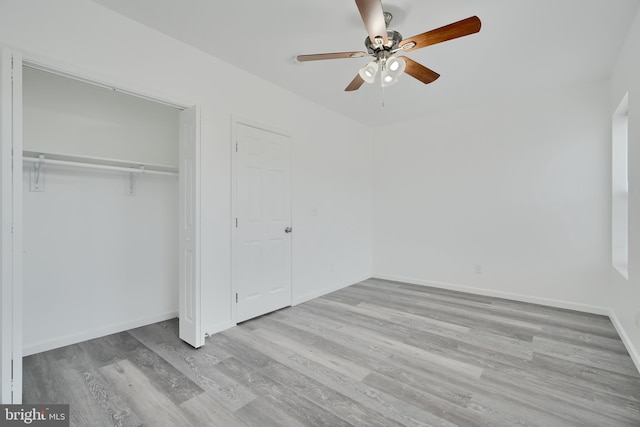unfurnished bedroom featuring wood finished floors, baseboards, ceiling fan, and a closet