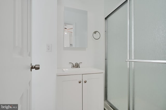 bathroom with vanity, a shower with door, and ceiling fan