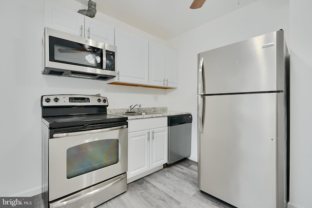 kitchen featuring appliances with stainless steel finishes, light wood-style floors, ceiling fan, and white cabinets
