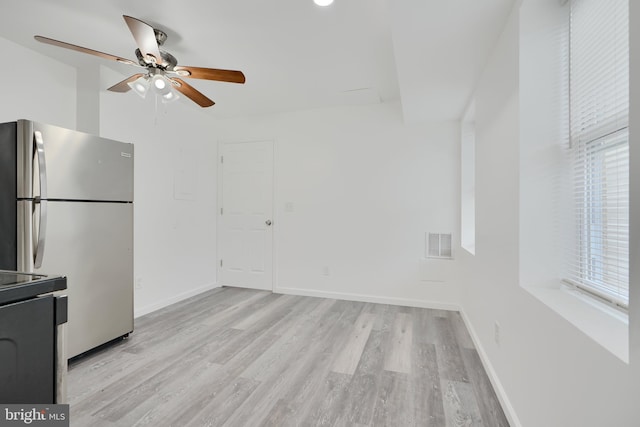unfurnished living room with ceiling fan, plenty of natural light, light wood-type flooring, and baseboards