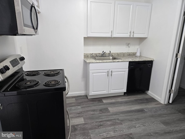 kitchen featuring electric range, stainless steel microwave, black dishwasher, a sink, and white cabinetry