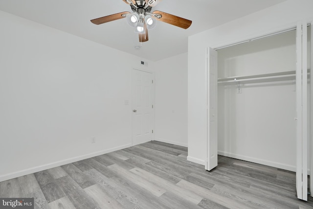 unfurnished bedroom with wood finished floors, a closet, baseboards, and ceiling fan