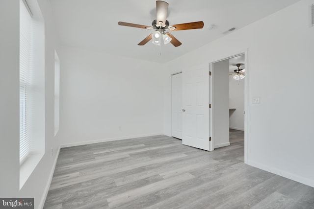 unfurnished room featuring ceiling fan, wood finished floors, and baseboards