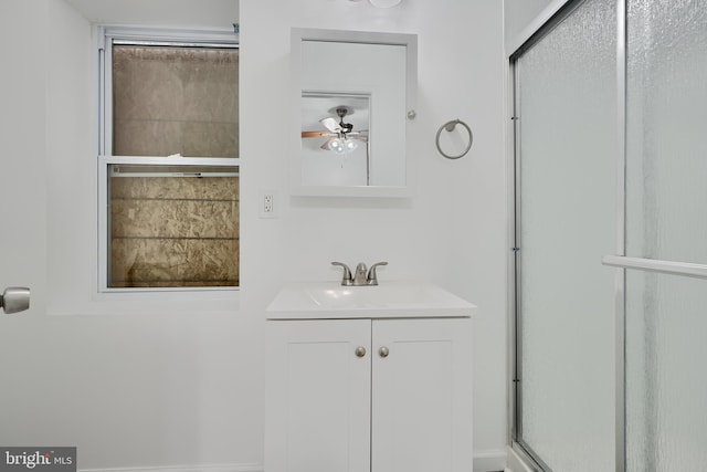 full bathroom with a shower stall, ceiling fan, and vanity