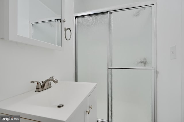bathroom with a shower stall and vanity