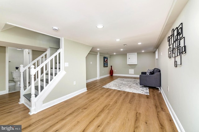 unfurnished room featuring recessed lighting, light wood-style flooring, stairway, and baseboards