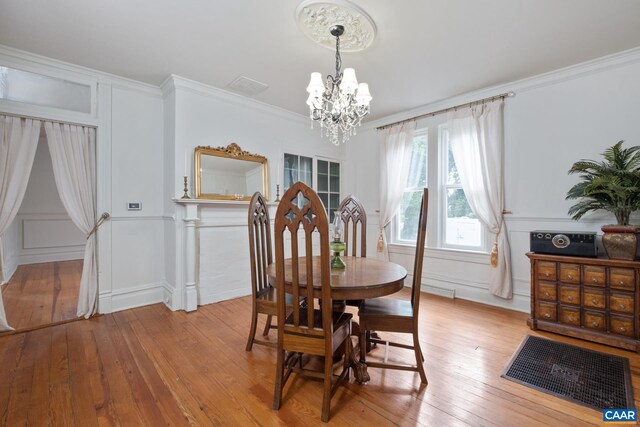 2010 White Bridge Rd, Waynesboro, VA 22980 - dining room featuring a chandelier, light wood-style flooring, a decorative wall, and crown molding