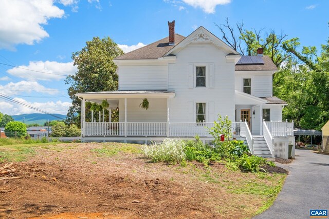 2010 White Bridge Rd, Waynesboro, VA 22980 - view of front of house featuring a chimney, a porch, solar panels, and roof with shingles