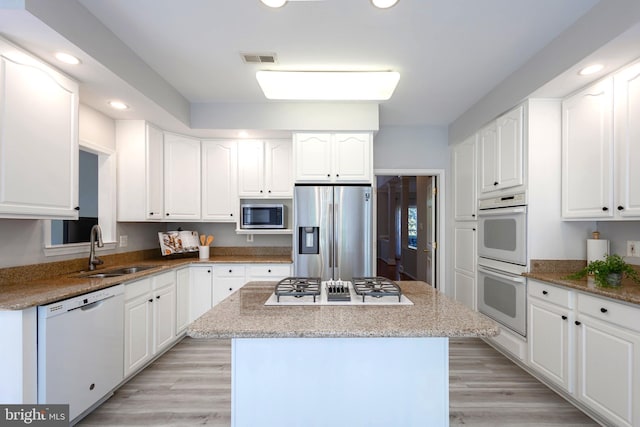 12685 Fox Woods Dr, Herndon, VA 20171 - kitchen featuring stainless steel appliances, a sink, a center island, recessed lighting, and white cabinetry