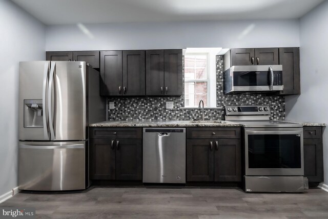 550 N 58th St, Philadelphia, PA 19131 - kitchen with stainless steel appliances, a sink, tasteful backsplash, light wood finished floors, and light stone counters
