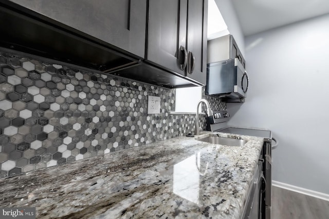 550 N 58th St, Philadelphia, PA 19131 - kitchen with stainless steel microwave, backsplash, a sink, light stone counters, and wood finished floors