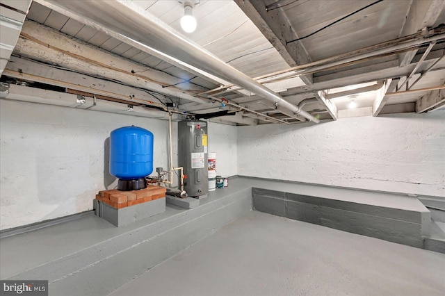 unfinished basement with water heater and a water pressure tank