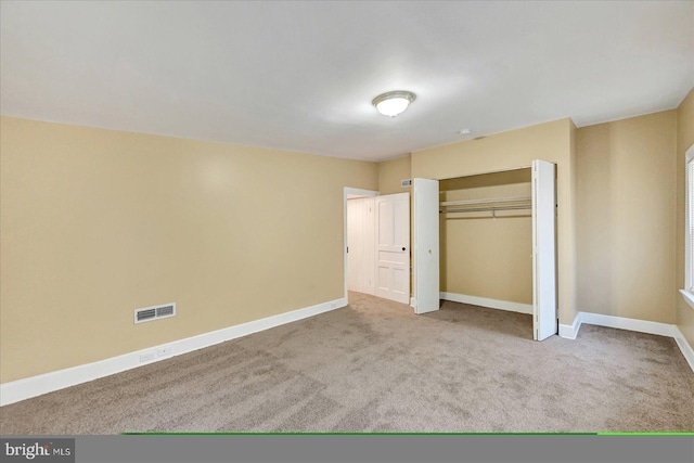 unfurnished bedroom featuring carpet flooring, baseboards, and a closet