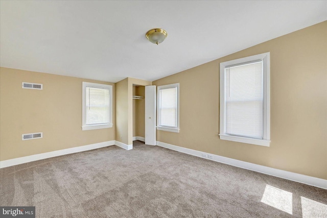 unfurnished bedroom with carpet floors, vaulted ceiling, and baseboards