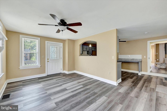 entrance foyer featuring a ceiling fan, wood finished floors, and baseboards