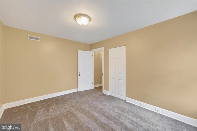 unfurnished bedroom featuring carpet and baseboards