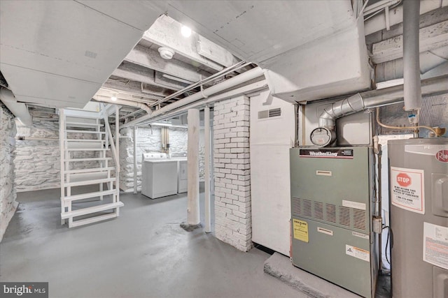 unfinished basement featuring electric water heater and washer and clothes dryer