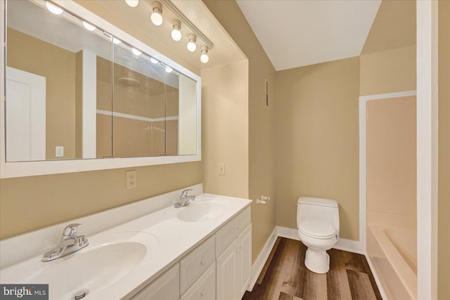 full bath with a shower, wood finished floors, toilet, and baseboards