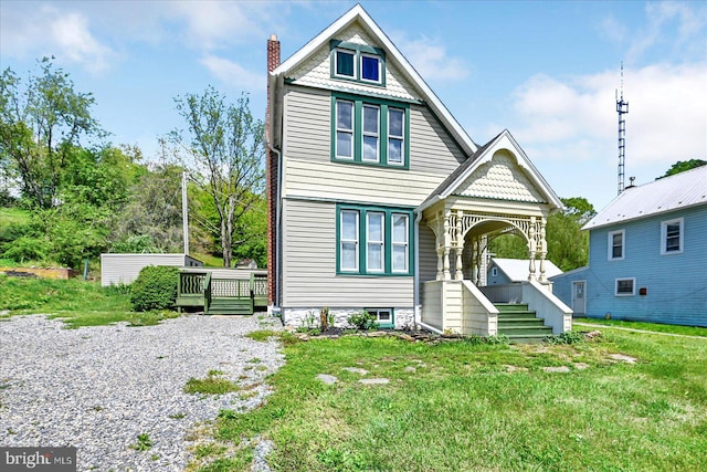victorian home featuring a chimney, a front lawn, and a deck