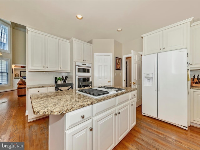 16013 Pheasant Ridge Ct, Woodbine, MD 21797 - kitchen with white appliances, light wood-type flooring, a kitchen island, white cabinets, and recessed lighting
