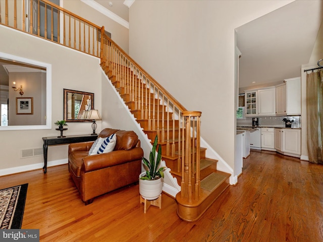16013 Pheasant Ridge Ct, Woodbine, MD 21797 - stairs featuring crown molding, wood finished floors, baseboards, and a towering ceiling