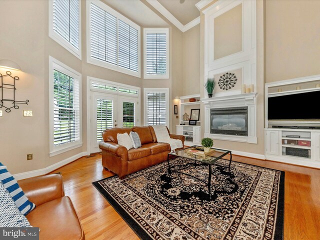 16013 Pheasant Ridge Ct, Woodbine, MD 21797 - living area with wood finished floors, baseboards, a towering ceiling, french doors, and ornamental molding
