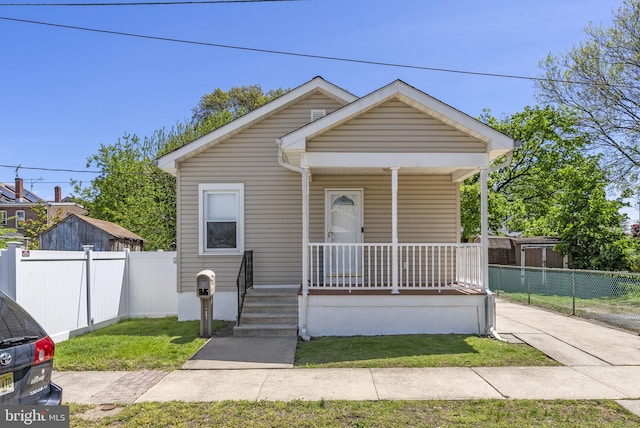 bungalow with covered porch and fence