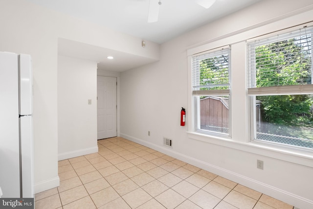 spare room with baseboards, a ceiling fan, and light tile patterned floors