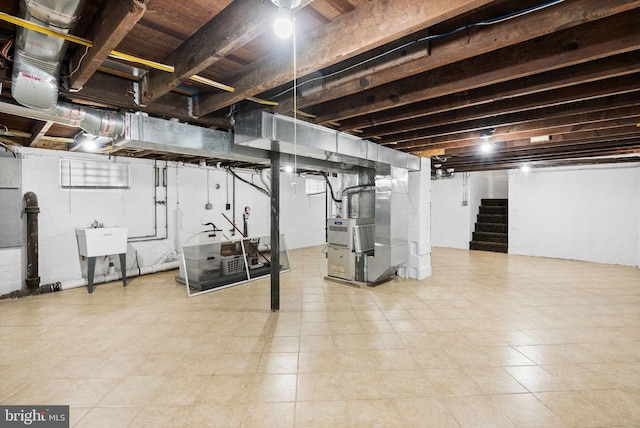 unfinished below grade area featuring stairway and heating unit